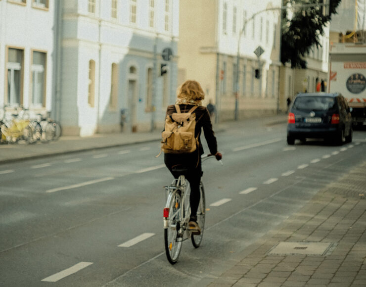 Vrouw op een fiets op een fietspad midden in de stad