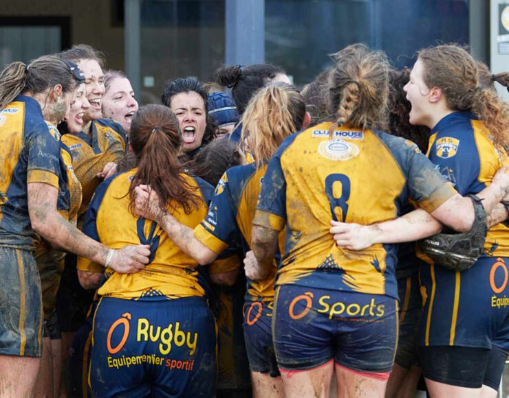 Rhone women's sports team hugging after a win
