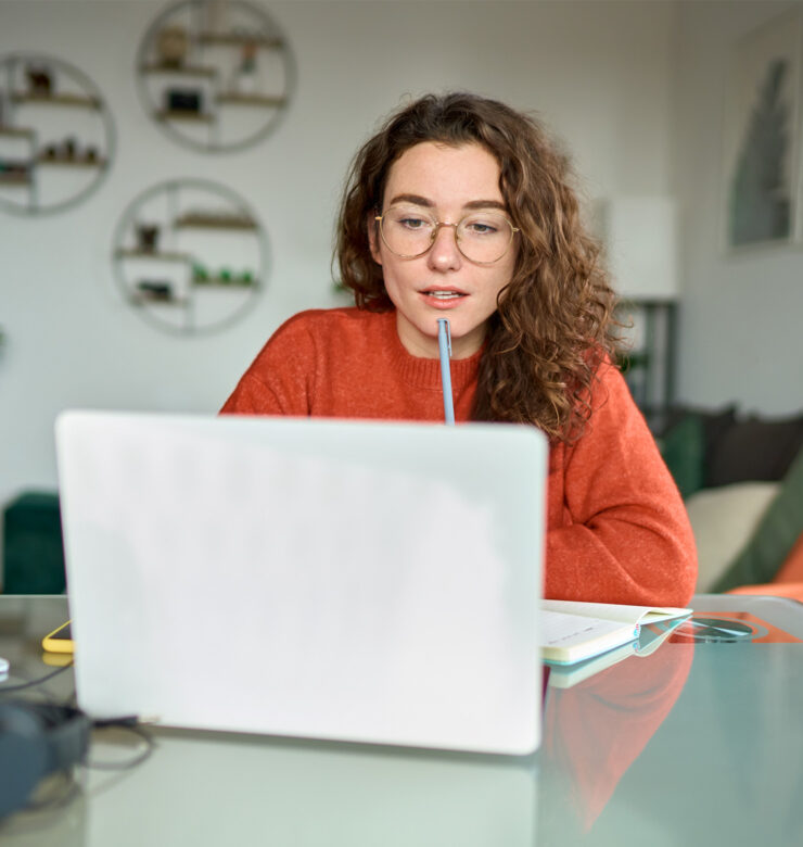 Een vrouw achter haar computer op zoek naar inspiratie