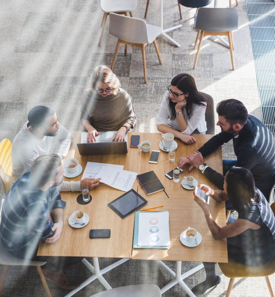 Six people drinking coffee in a meeting