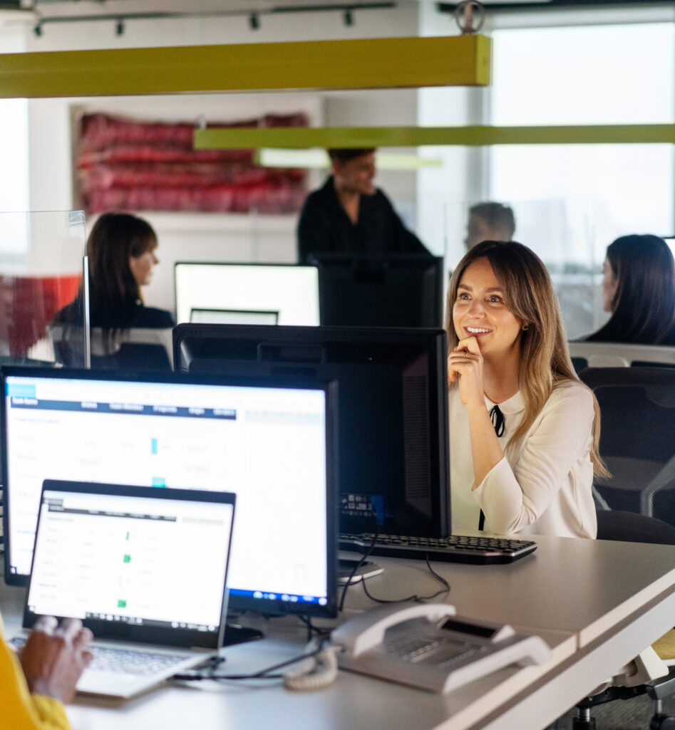 A woman in front of her computer in an open space