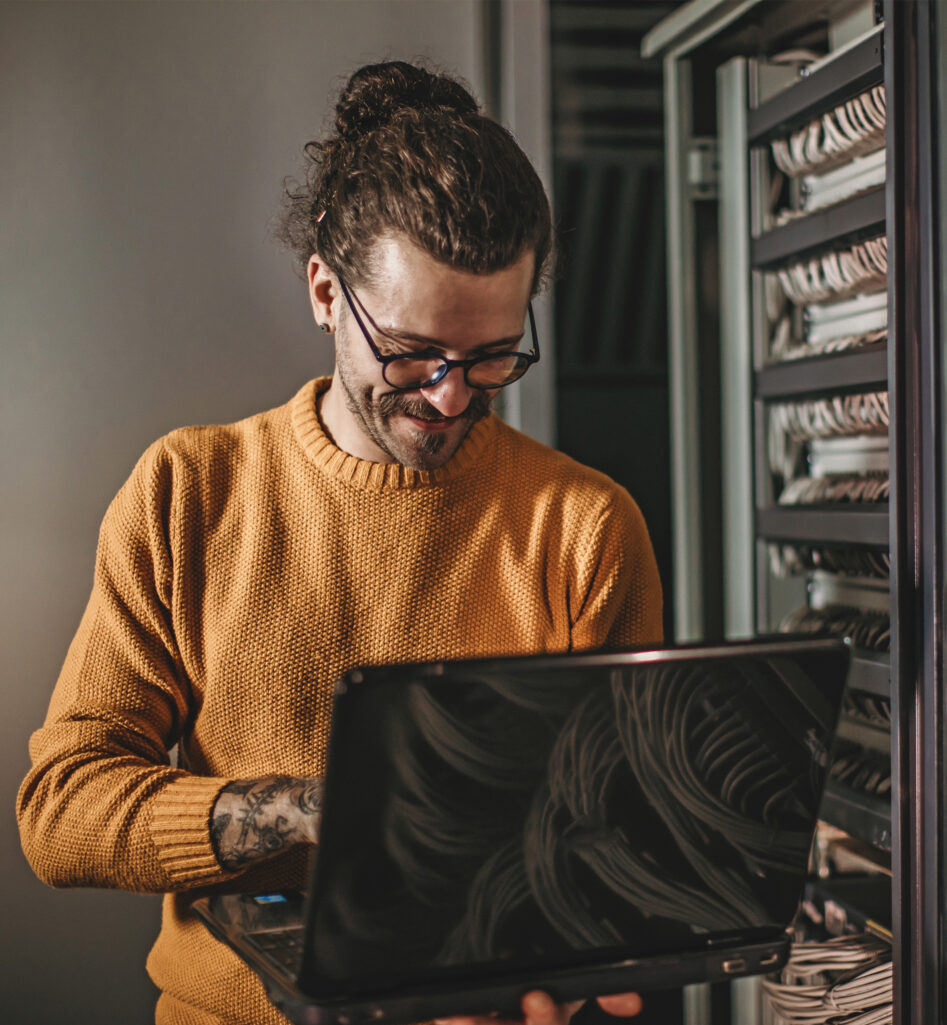 A man working with his computer in a datacenter