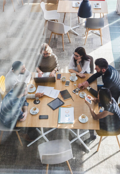 Six people drinking coffee in a meeting