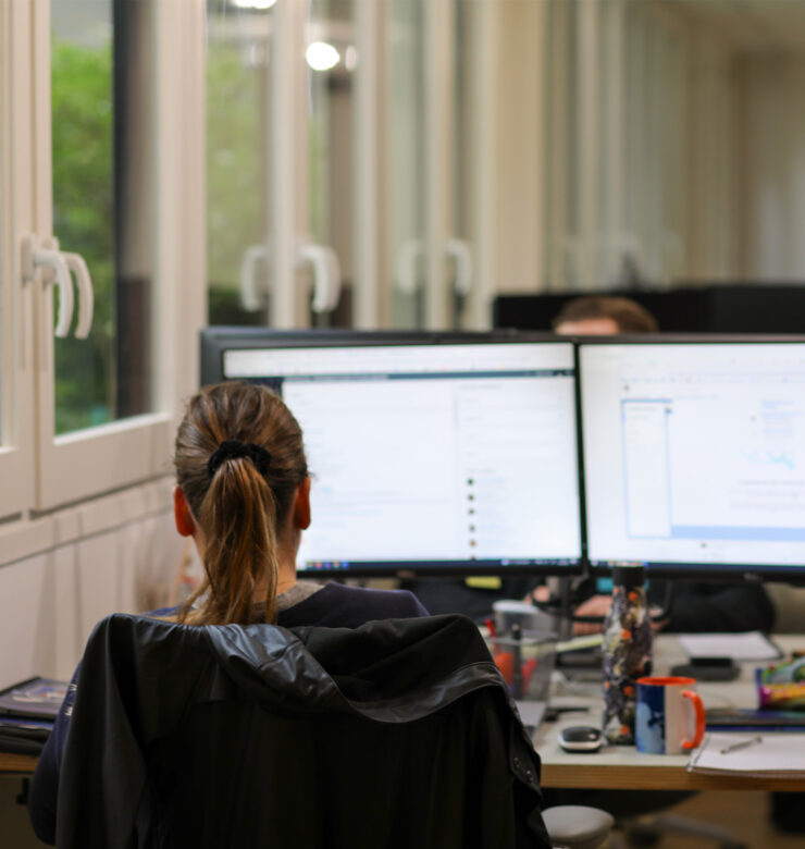 Woman with back working on her computer