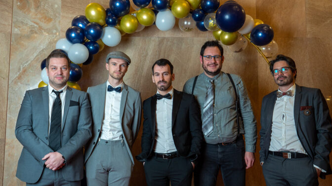 Team in front of a balloon arch