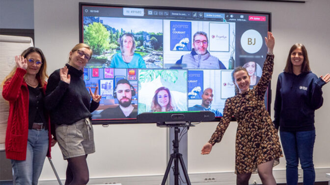 Réunion hybride où 4 femmes sont devant la télévisionqui retransmet la visio