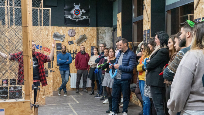 Team in an axe-throwing room for an end-of-year party
