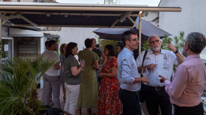 Standing team sharing an aperitif cocktail at an afterwork party