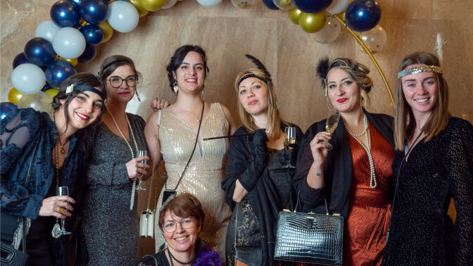 Group posing in front of a baloon arch