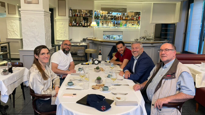 Five people around a table preparing to have lunch