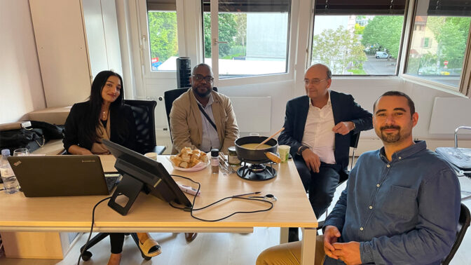 Four people around a table with a fondue machine