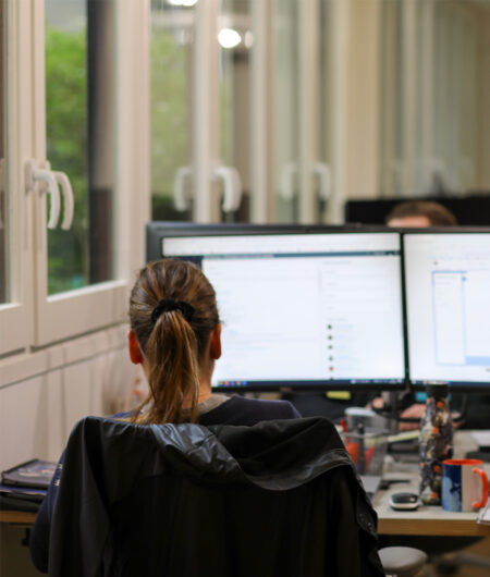 Vrouw met haar rug aan het werk op haar computer