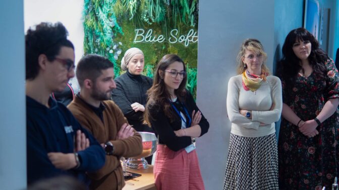 Verschillende mensen luisteren tijdens een afterwork voor onze teams bij Blue Soft Consulting