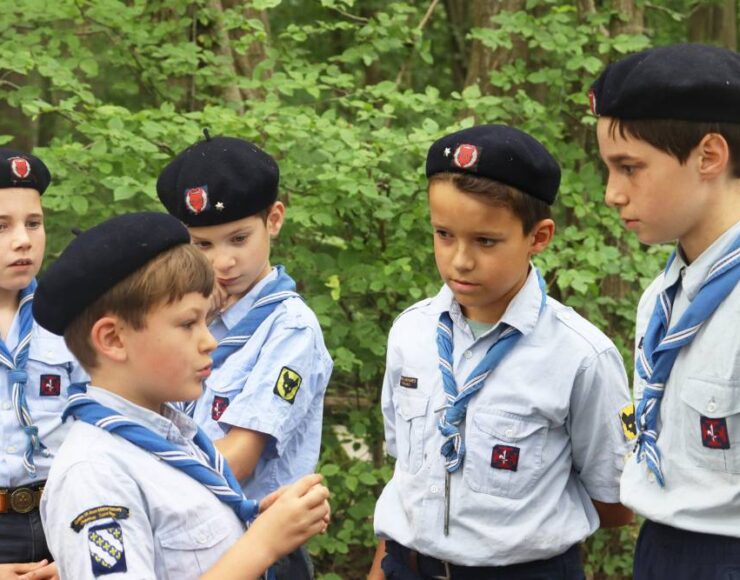 Plusieurs enfants de sexe masculin habillés avec leurs tenues de scouts en train de parler, pour illustrer Scouts unitaire de France association soutenue par le groupe Blue Soft dans le cadre du Projet Indigo 2026